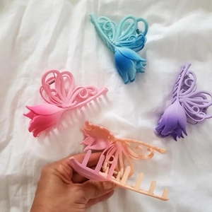 Detail of tulip and butterfly hair claws in matte gradient pink, blue, and purple colors