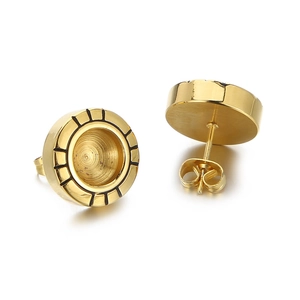 Détail des boucles d'oreilles rondes en titane doré avec motifs de lignes noires