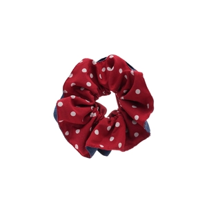 Red fabric hair scrunchie with white polka dots and navy blue inner lining details
