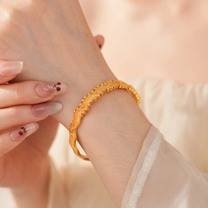 Close-up of vintage brushed gold bracelet with small diamonds on model's wrist