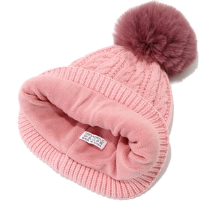 Detail der rosa Strickmütze mit warmem Fleecefutter und flauschigem Kunstpelz-Bommel