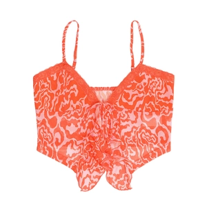 Dettaglio della canotta in mesh a fiori rossi con bordo in pizzo e fiocco decorativo