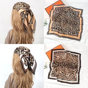 Detail of leopard print silk scarves worn as a headband and laid flat on a box