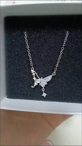 Detailed view of silver butterfly necklace with white zircon in a white gift box