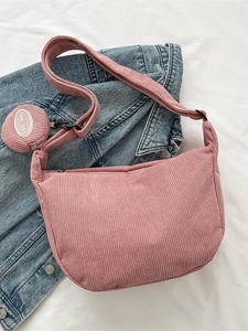 Pink corduroy crossbody dumpling bag with matching coin purse on denim jacket