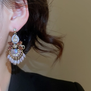 Nahaufnahme von Vintage-Ohrringen mit Kristallen und lila Tropfenperlen am Modell