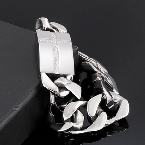 Vue macro du bracelet gourmette en acier titane argenté avec plaque croix sertie