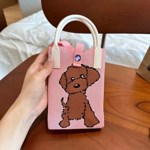 Détail d'un mini sac tricoté rose avec motif caniche marron et bouton étoilé bleu