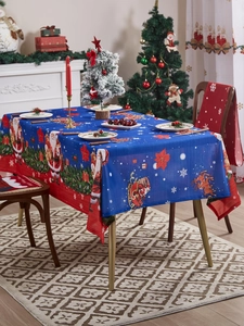 Detail of blue Christmas tablecloth featuring Santa, reindeer and poinsettia patterns