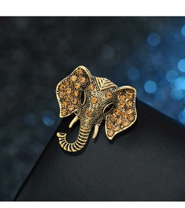 Detailed close-up of a vintage golden elephant head brooch with amber rhinestones