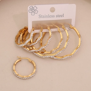 Detail of gold-plated stainless steel hoop earrings with sparkling white crystals