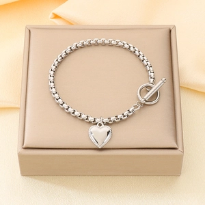 Dettaglio del ciondolo a cuore argento e chiusura OT sul bracciale a catena