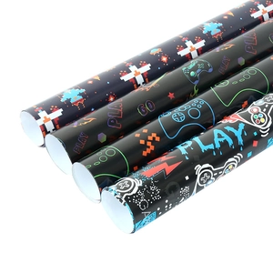 Black video game wrapping paper rolls with pixel art controllers and PLAY patterns