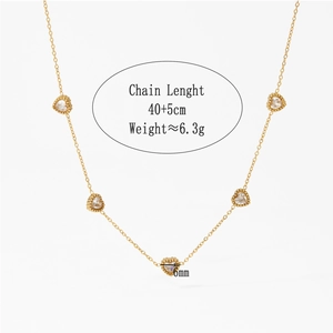 Detail of gold stainless steel necklace with five heart pendants and crystals