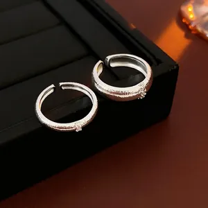 Minimalist silver open ring with brushed texture and zircon stone on display