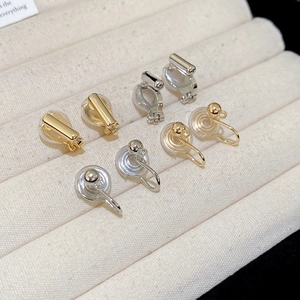 Detailed view of gold and silver U-shaped clip-on earring converters with silicone pads