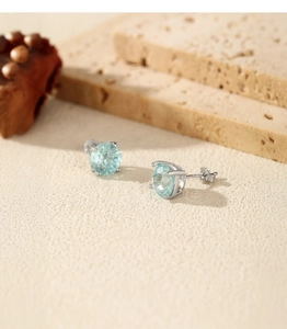 Macro view of light blue firework-cut zircon earrings in S925 sterling silver four-prong setting