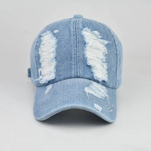 Distressed light blue denim baseball cap with vintage frayed holes and curved brim style