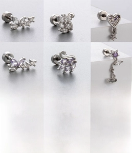 Macro detail of silver titanium steel piercing studs with butterfly and swan zircon shapes