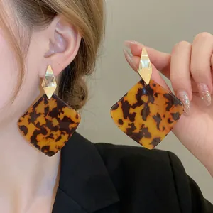 Fashionable amber resin hoop earrings with geometric gold-tone diamond-shaped studs