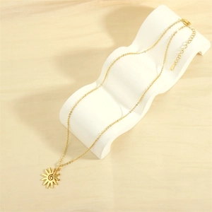 Close-up of golden solar spiral pendant necklace on elegant white display stand