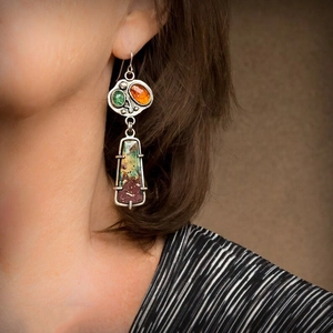 Bohemian vintage long drop earrings with green and orange stones on a female model