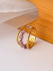 Detail of gold layered ring with hammered texture and purple crystal beads in vintage style