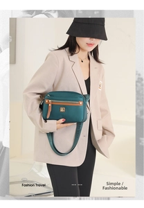 Detail of dark green waterproof nylon crossbody bag with adjustable wide fabric strap