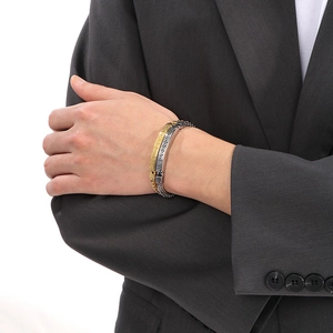 Macro view of two-tone stainless steel dragon chain bracelet with Greek key pattern
