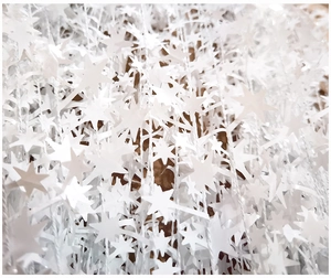 Macro shot of white star-shaped Christmas tinsel garlands for festive DIY decoration