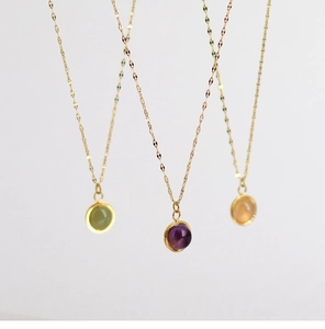 Close-up of elegant 18K gold-plated necklaces with colorful natural stone pendants