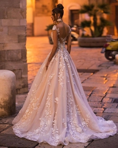 Close-up of champagne bridal gown with floral lace embroidery and open back detail