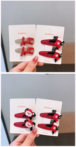 Detail of Christmas hair clips featuring reindeer, Santa, and stockings on glitter bases