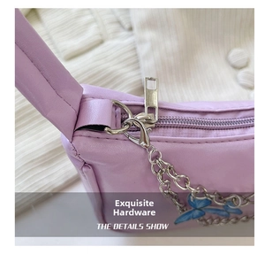 Detail of silver zipper and blue butterfly charm on a purple faux leather shoulder bag