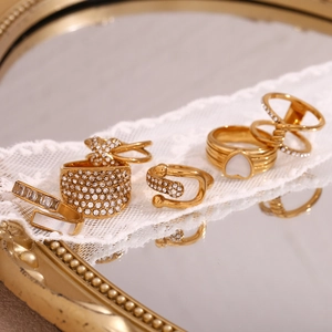 Macro view of 18K gold plated stainless steel rings with rhinestones on white lace