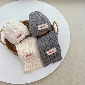 Detail von Strickmütze und Schal Set mit Zopfmuster und EIGHT Aufnäher in Grau