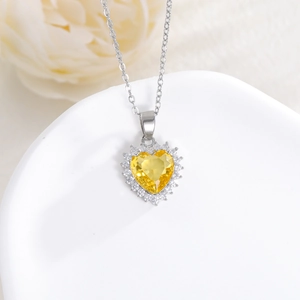 Detailed close-up of a heart-shaped yellow zircon pendant on a silver necklace chain