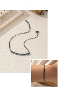 Gunmetal silver bracelet featuring dual-row turquoise stones on a curved bar detail