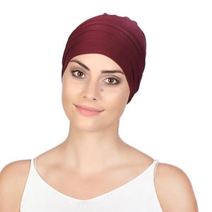 Detail of burgundy pleated chemo headwear on model with soft high-elastic fabric texture