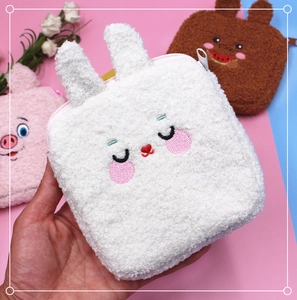 Close-up of white rabbit plush pouch with embroidery detail and teddy fleece texture