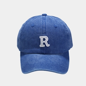 Detailed close-up of vintage washed navy cotton fabric and white R letter embroidery