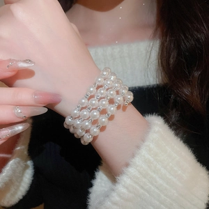 Detail of multi-layer pearl bracelet with rhinestones worn on a model's wrist