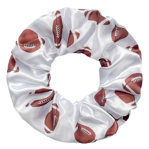 Détail d'un chouchou en satin blanc avec motif de sport de football américain imprimé