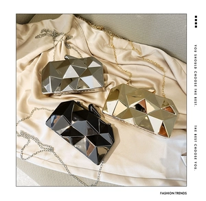 Detailed view of geometric acrylic clutch bags in gold, silver and black with chains