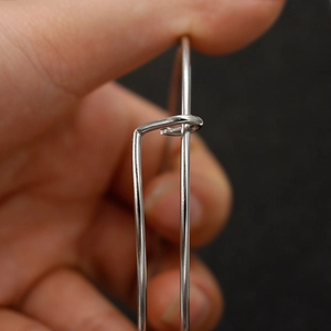Detail shot of 1.6mm stainless steel wire bracelet showing hook closure mechanism