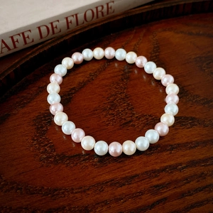 Gros plan détaillé d'un bracelet de perles vintage bicolores sur un plateau en bois élégant