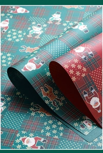 Detail of waterproof Christmas wrapping paper with festive Santa and reindeer patterns