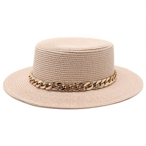 Close-up of the woven texture and gold chain detail on a beige flat top straw boater hat