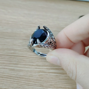 Detailed close-up of a men's punk dragon claw ring with a black oval gemstone inlay