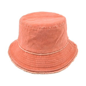 Detail of frayed edges and stitching on a vintage washed cotton bucket hat in brick red